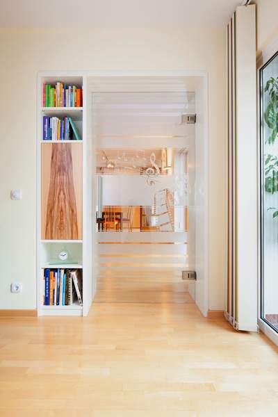 Raumteiler mit Glastür Auch in der Gestaltung des Bücherregals findet sich das charaktervolle Red Gum Holz wieder. Somit fügt sich auch dieses Element harmonisch in das Gesamtkonzept ein.